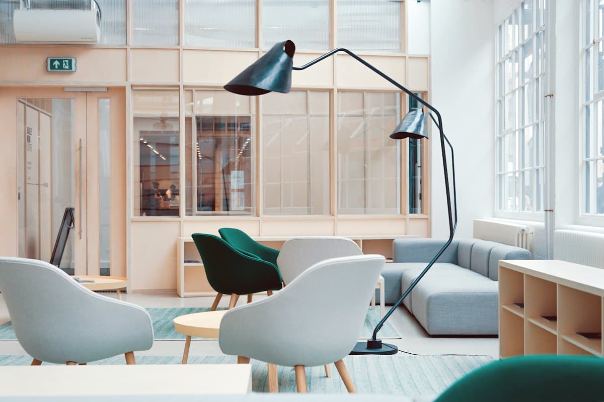Geniş pencereli, oturma gruplarıyla düzenlenmiş modern ofis alanı